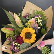 A hand tied of florist choice in bright blooms