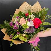 A hand tied of florist choice in pink &amp; purples 